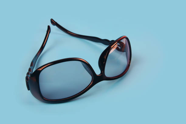 istock Women's black sunglasses isolated on blue background 1201782392