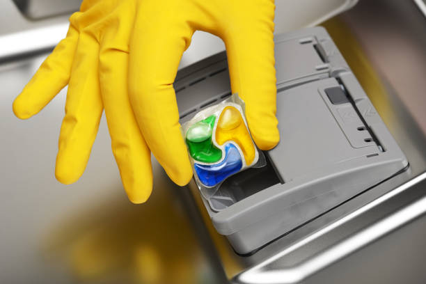 ręczne wkładanie tabletki detergentu do wody do naczyń - dishwashing detergent zdjęcia i obrazy z banku zdjęć