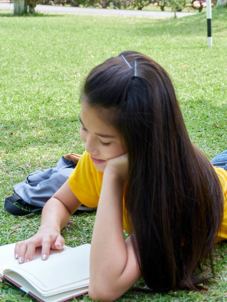 istock Female student studying outdoors read a book in the park. 1201786513