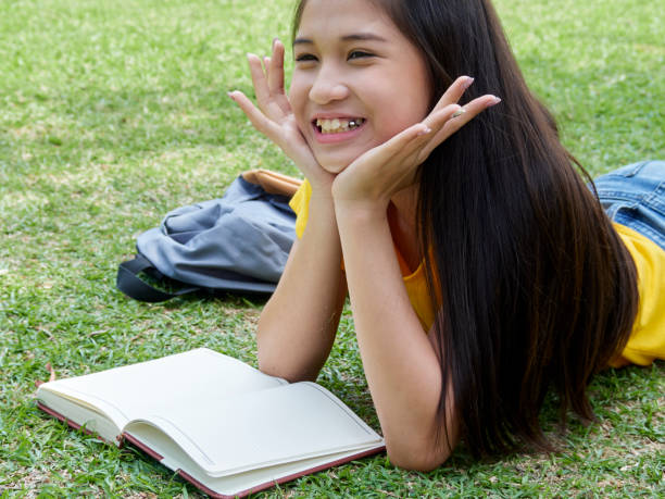 istock Female student studying outdoors read a book in the park. 1201786530