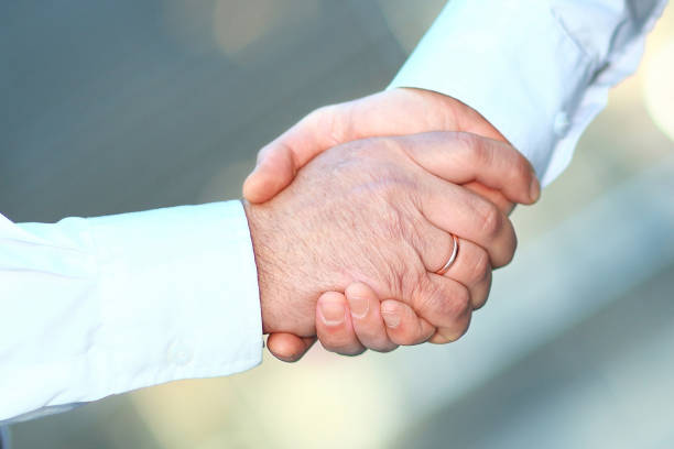 istock closeup. handshake business people in blurred background. 1201787736