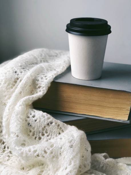 istock White coffee cup to go standing on books 1201795427