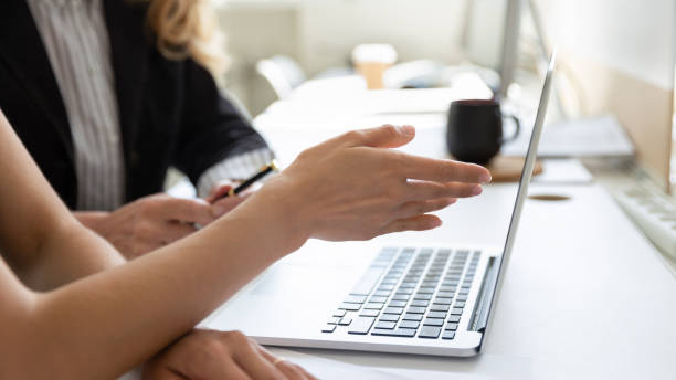 Closeup female pointing on pc screen discuss project with teammate