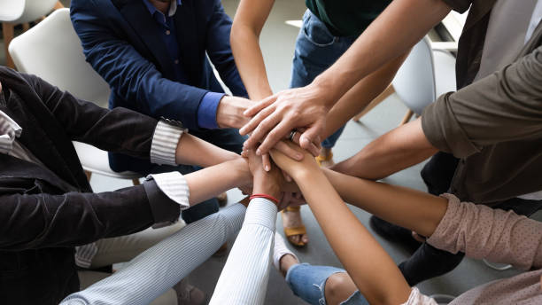 istock Top view hands stacked together as symbol of teambuilding 1201798740