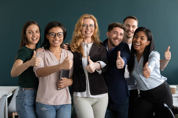 istock Interns and aged ceo looking at camera showing thumbs up 1201798757