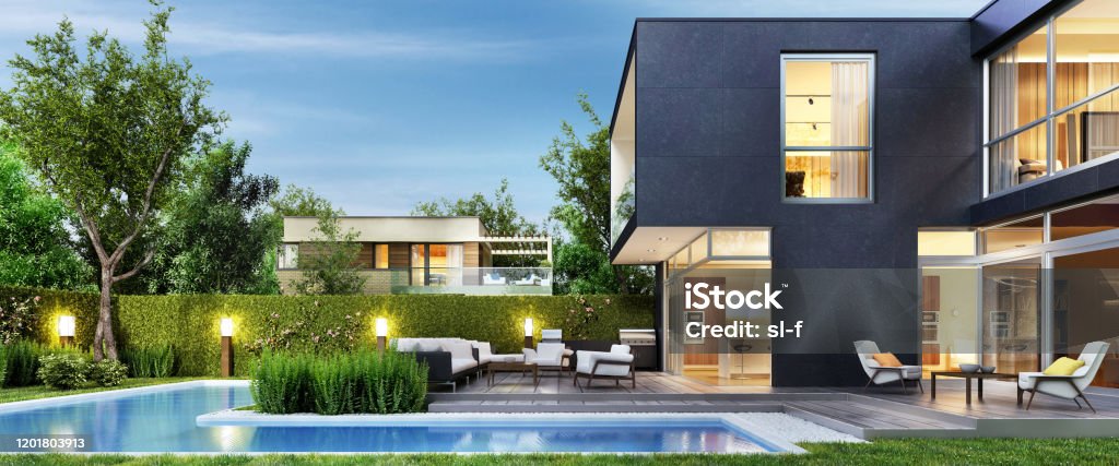 Modern black house with patio and pool Evening view. Interior and exterior House Stock Photo