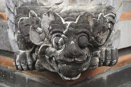 Ancient carved stone guardian statue at a Hindu temple in Bali Indonesia