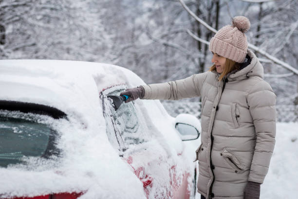 istock Girl scraping ice from a car 1201806360