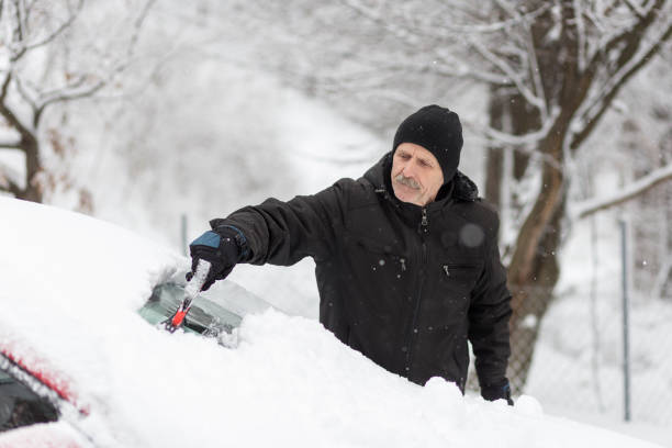 istock Man using ice remover on his car on a winter morning 1201806380