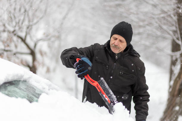 istock Concerned man removing snow from his car 1201806391