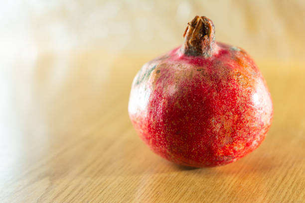 istock Red ripe pomegranate one and brown background. 1201808516