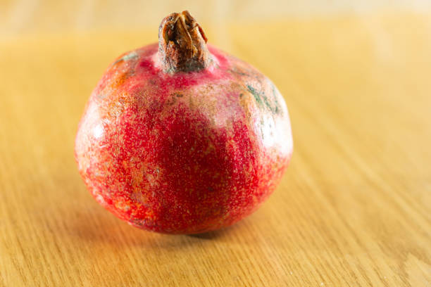 istock Red ripe pomegranate one and brown background. 1201808517