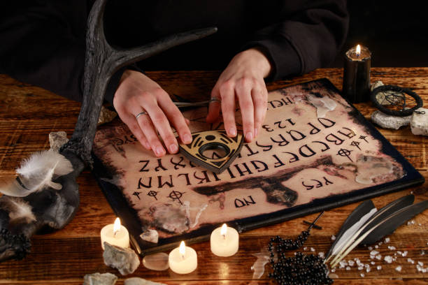 istock Hands on the devil's board. Session of calling spirits. Occult sciences, the atmosphere of black magic. 1201809051