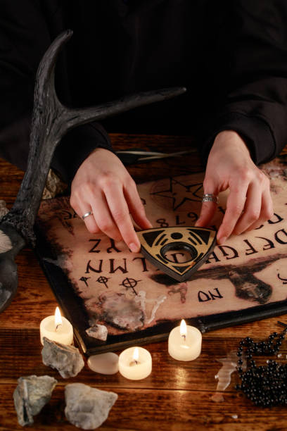 istock Hands on the devil's board. Session of calling spirits. Occult sciences, the atmosphere of black magic. 1201809583