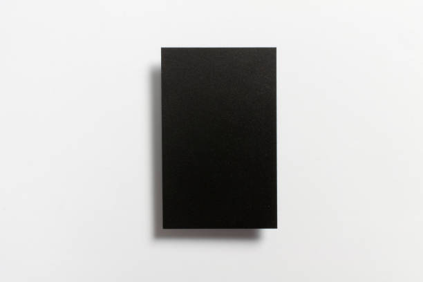 istock Black blank matt surface textured vertical business card flying and isolated on white background, UK standard size 85 mm wide x 55 mm high, real professional studio photo. 1201809828