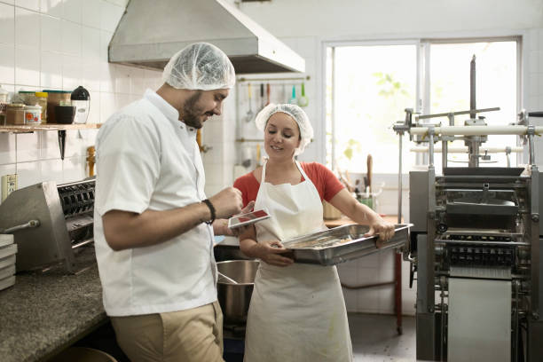 istock Hispanic Worker Using Digital Tablet and Talking to Coworker 1201811058