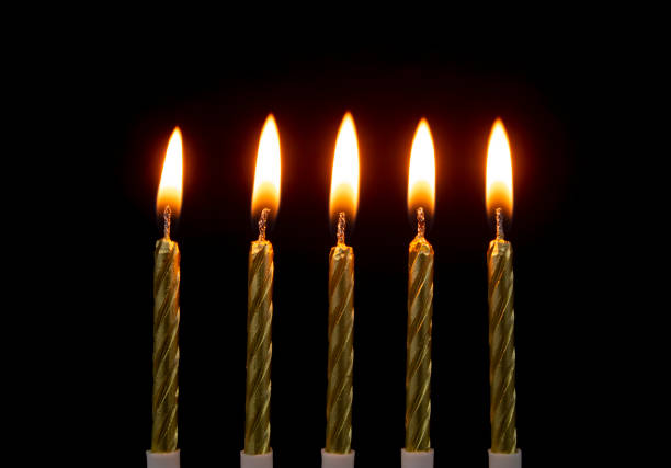 istock Burning golden candles on black 1201812184