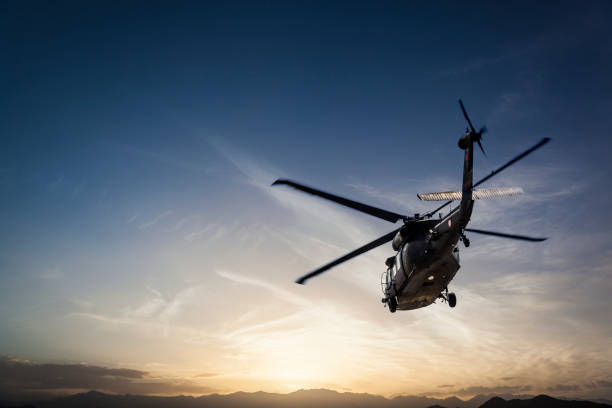 日没に対して飛ぶ写真軍用ヘリコプター - us military ストックフォトと画像