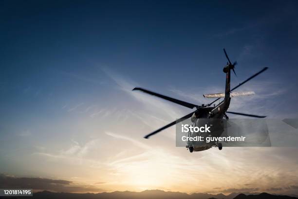 Photos Military Helicopter Flying Against Sunset Stock Photo - Download Image Now - Helicopter, Military Helicopter, US Military