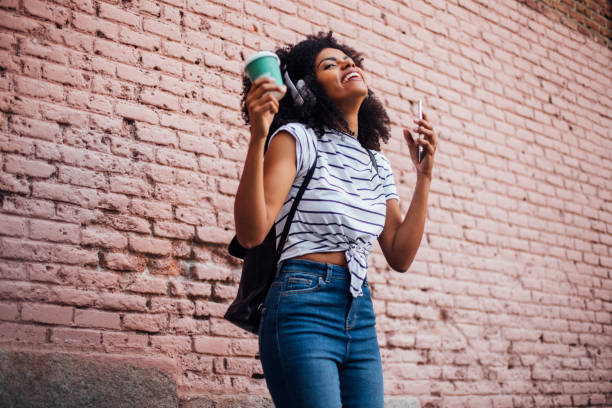 istock Girl dancing and drinking coffee outdoors 1201817747