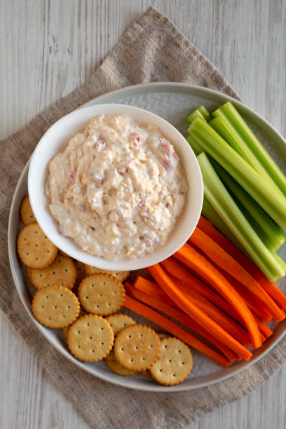 istock Homemade Pimento Cheese Dip with carrots, celery and crackers, overhead view. Flat lay, top view, from above. 1201817826