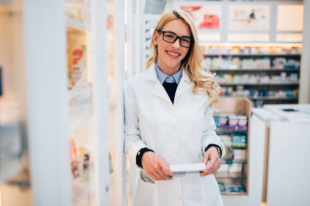 istock Young pharmacist showing a box of medicine 1201818891