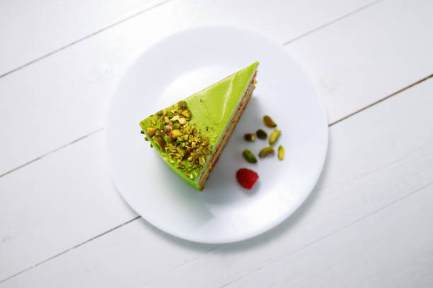 Cake with fruity cream and pistachio decorated with nuts, isolated on wooden background