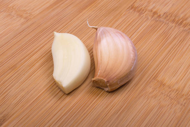 two heads of garlic on a wooden board top view, close-up