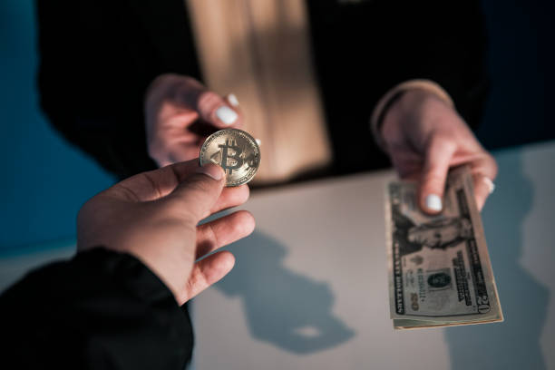 Exchanging Bitcoin with United States Dollar Bill stock photo