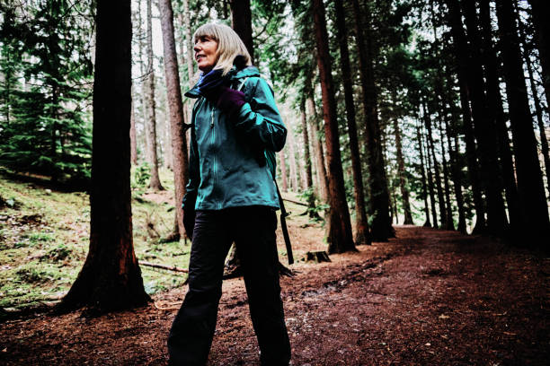 istock Mature woman on a forest and lakeside walk 1201824725