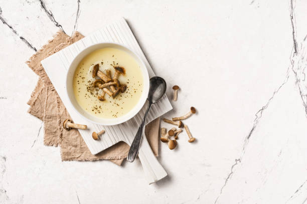 vista dall'alto della zuppa autunnale di crema vegetale in ciotola marrone con agarici al miele o armillaria - honey agaric foto e immagini stock