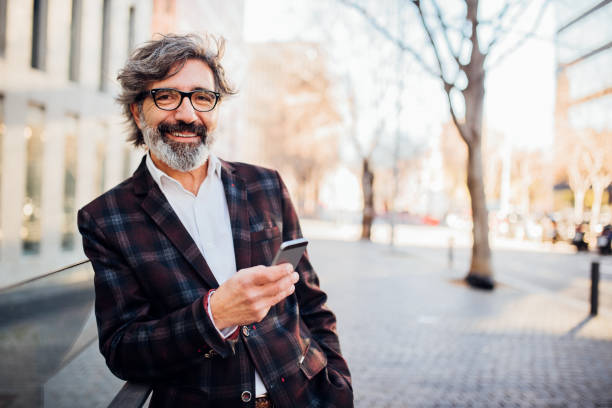 istock Mature businessman texting on the street 1201826193