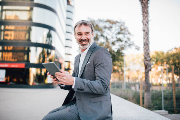 istock Senior man in a suit looking at a tablet 1201827266