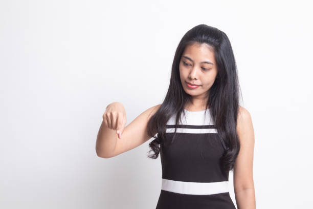 istock Beautiful young Asian woman point down to blank space. 1201827403