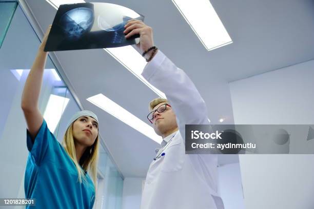 Young Healthcare Professional Looking Xray Of The Patients Skull Stock Photo - Download Image Now