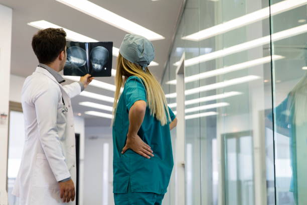 joven profesional de la salud que mira rayos x del cráneo del paciente - x ray image radiologist examining using voice fotografías e imágenes de stock