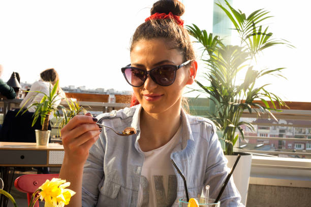 istock Young woman in outdoors cafe 1201828346