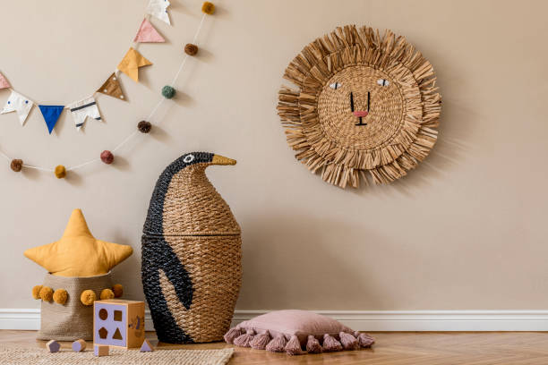 Stylish and modern scandinavian newborn baby interior with mock up photo or poster frame. Wooden toys and accessories. elegante interior escandinavo de la habitación para niños con juguetes naturales, decoración colgante, almohadas, animales de felpa, osos de peluche y accesorios. paredes beige. diseño interior de la habitación para niños. plantilla. copiar espacio.