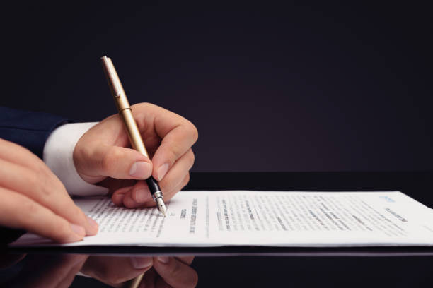 istock Lawyer, notary, attorney signs document 1201834045