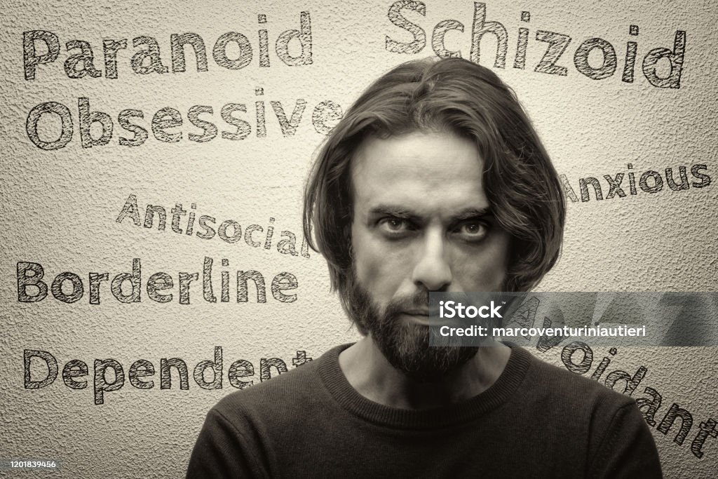 Personality disorders Personality disorders: paranoid; schizoid; antisocial; borderline; obsessive; anxious; avoidant; dependent... are written on a white wall behind a man who doesn't look too happy! Photography Stock Photo