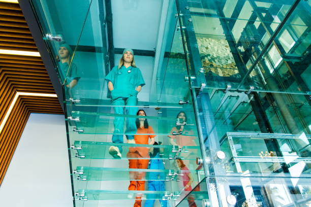 istock Medical professionals walking on modern glass staircases 1201841839