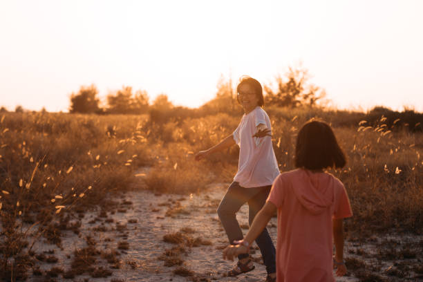 istock Asian Mother and Daughter Laughing and Running in the Fields 1201846899
