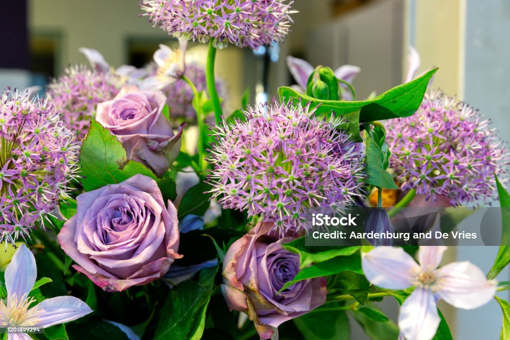 Close up flower bouquet Bouquet with purple flowers and green leaves Arrangement Stock Photo