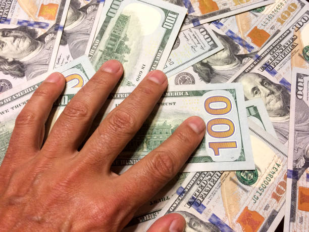 istock American dollar bills with hand on money 1201849318