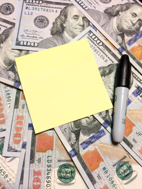 Dollar bills cash with post it note and sharpie vertical Dollar bills cash with post it note and sharpie black marker vertical philadelphia federal reserve stock pictures, royalty-free photos & images