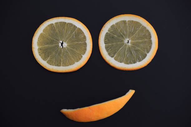 黒い背景ビューで孤立した新鮮なオレンジ色の笑顔のスライス - half smile ストックフォトと画像