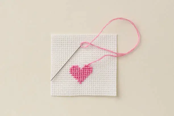 cross-stitch heart with needle and thread