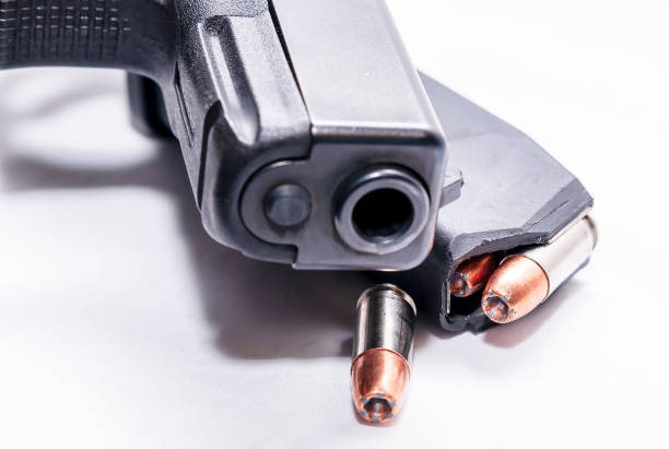 istock A black 9mm semi automatic pistol with a loaded pistol magazine with a single 9mm hollow point bullet 1201851719