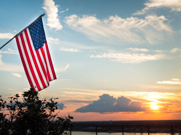 helle amerikanische flagge weht über schönem sonnenuntergang über mississippi fluss - allegory painting fotos stock-fotos und bilder