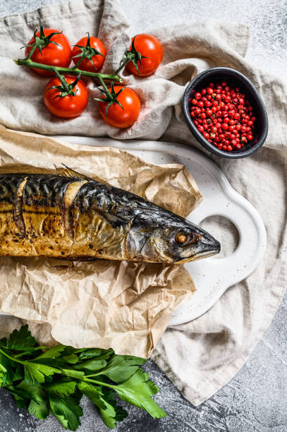 istock smoked mackerel with parsley and cherry tomatoes. Gray background. Top view 1201861771